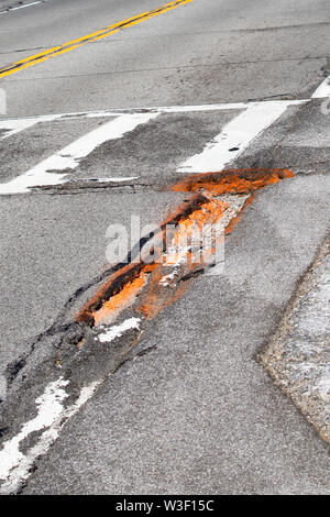 Potholes in the asphalt on a street in Speculator, NY USA, a hazard to motorists. Stock Photo