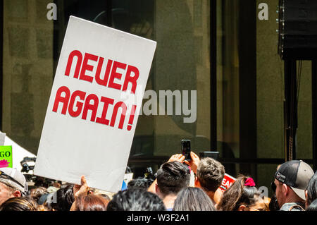 Downtown, Chicago-July 13, 2019: Protest against Immigration ICE and Border Patrol. A sign reads 'Never Again!' Stock Photo