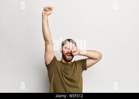 sleepy man yawning and stretching, isolated on a white background. monday, cheerful guy having good mood in the morning Stock Photo