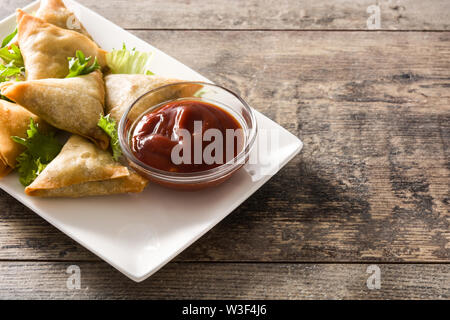 Samsa or samosas with meat and vegetables on wooden table. Traditional Indian food. Stock Photo