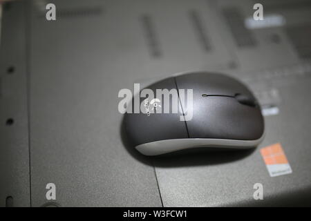 Logitech bluetooth wireless mouse on back of laptop Stock Photo