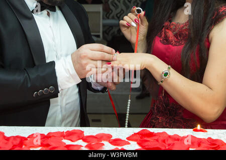 Rings and hands of bride and groom. young wedding couple at ceremony. matrimony. man and woman in love. two happy people celebrating becoming family . Stock Photo