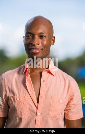 Handsome African American man smiling off camera. Photo of a man taken outside with blurry background Stock Photo