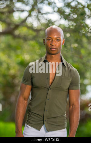 Portrait of a handsome African American male model posing in a vintage retro shirt at a park setting summer Stock Photo