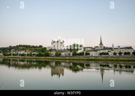 Views of the city of Saumur from the riverbank at dusk, with the castle in the background. Loire Valley, France. Stock Photo