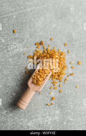 Crystalized brown sugar in wooden scoop. Top view. Stock Photo
