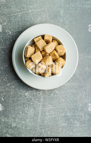 Brown sugar cubes in bowl. Top view. Stock Photo