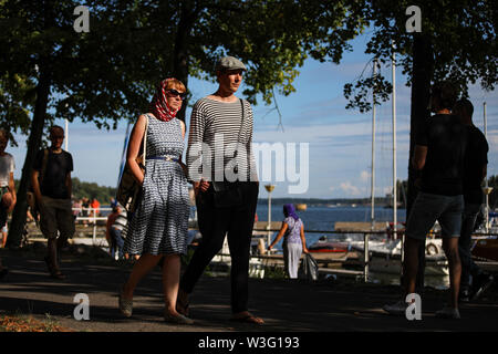 Stylish couple in summer cloths strolling along Merihaka seaside during Kallio Block Party 2018 in Helsinki, Finland Stock Photo