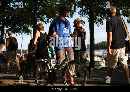 Young man walking a bike along Merihaka seaside during Kallio Block Party 2018 in Helsinki, Finland Stock Photo