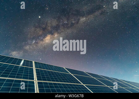 Solar Energy Panels view, a nice technology blue pattern at Atacama Desert arid lands. The solar modules going to the infinity with the Milky Way Stock Photo