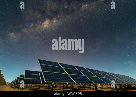 Solar Energy Panels view, a nice technology blue pattern at Atacama Desert arid lands. The solar modules going to the infinity with the Milky Way Stock Photo