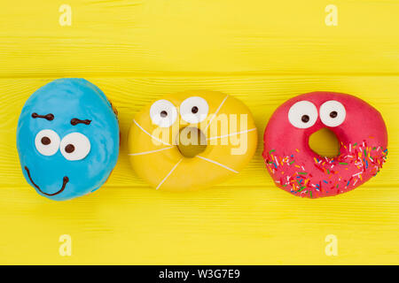 Funny colorful donuts on yellow background. Stock Photo