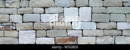 Old stone wall made of square natural stones Stock Photo