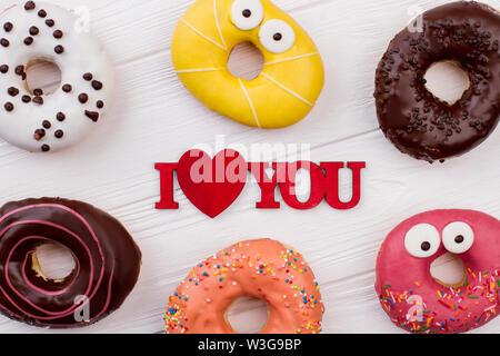 Multicolored donuts on wooden background. Stock Photo