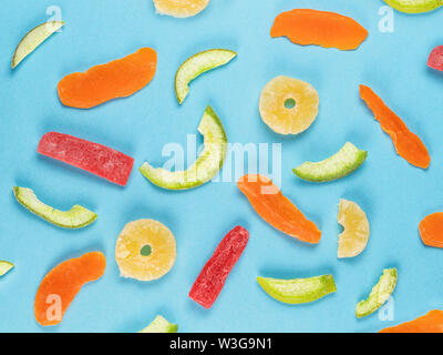 Different candied fruits on blue background. Top view, flat lay. Stock Photo
