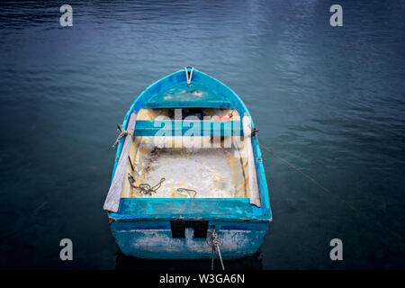 Small blue wooden rowing fisherman boat in the port and harbour in the Alykes Bay in Zante, Greece