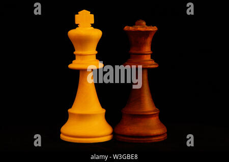 White King, Black Queen as mixed couple concept.Standard chess wooden pieces on black background Stock Photo