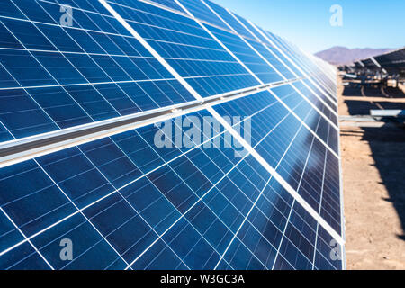Solar energy modules row going to the infinity on an arid climate landscape at Atacama Desert Stock Photo