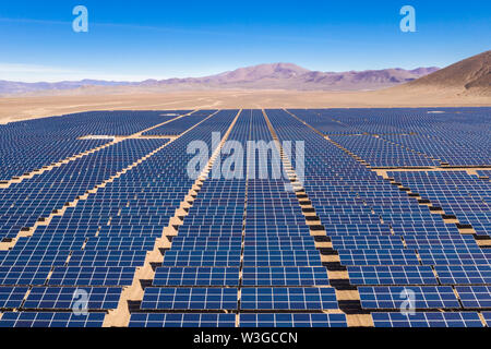 Aerial view of hundreds solar energy modules or panels rows along the dry lands at Atacama Desert, Chile. Huge Photovoltaic PV Plant in the desert Stock Photo