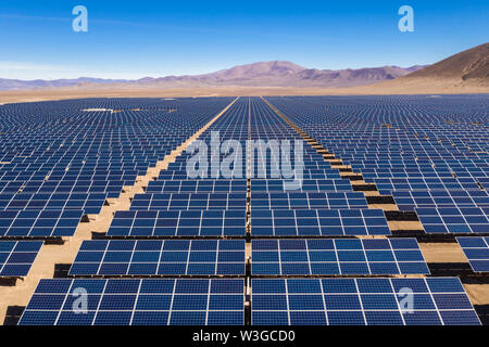 Aerial view of hundreds solar energy modules or panels rows along the dry lands at Atacama Desert, Chile. Huge Photovoltaic PV Plant in the desert Stock Photo