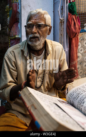 UDAIPUR, INDIA - CIRCA NOVEMBER 2018: Priest on the street of Udaipur at night. The city is the historic capital of the kingdom of Mewar. Surrounded b Stock Photo