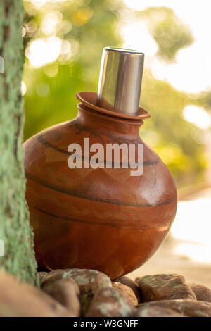 Clay Pot Water placed under shade of tree in summer for drinking water. Stock Photo
