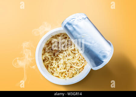 Instant cup noodle on yellow background Stock Photo