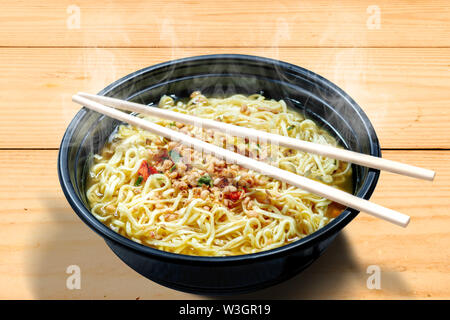 Noodles on the bowl with chopstick on wooden table background Stock Photo