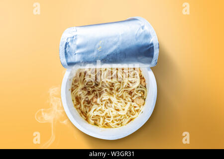 Instant cup noodle on yellow background Stock Photo