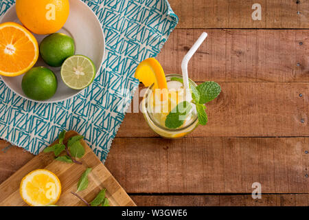 Orange, Lime and Mint healthy summer infused water refreshment on wooden tabletop with copy space for text. Stock Photo