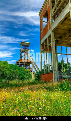 A disused coal mine pithead winding gear of an old Belgian coal mine shaft against a clear blue sky Stock Photo