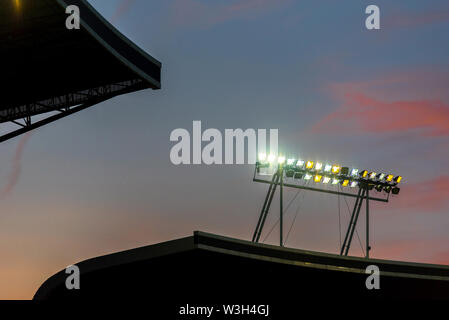 Stadium lights against blue sky during sunset Stock Photo