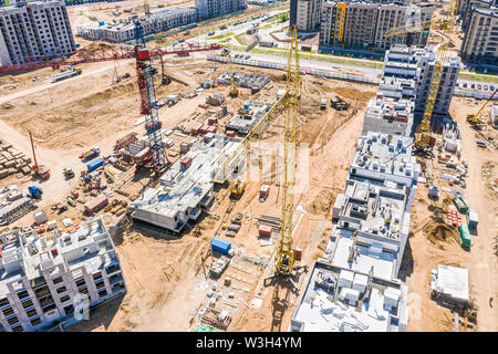 aerial panoramic view of city construction site with industrial tower cranes and other building heavy machinery Stock Photo