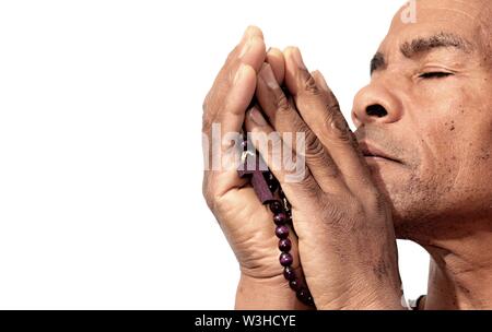 black man praying to god with cross and hands together Caribbean man praying with white background stock image stock photo