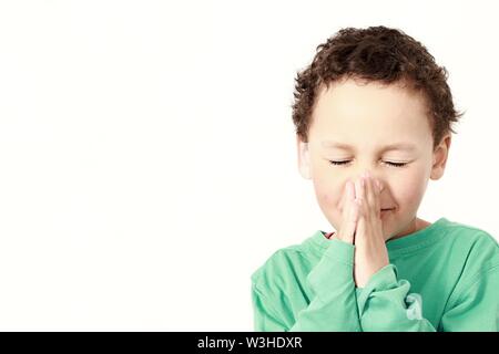 little boy praying to God and being religious stock image with hands held together praying in church on sunday stock photo Stock Photo