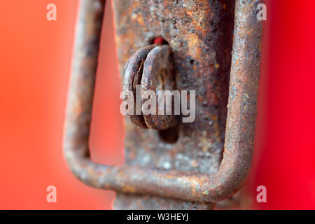 Rusty, Weathered Hasp and Staple on Orange, Red Background Stock Photo