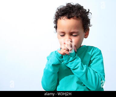 little boy praying to God and being religious stock image with hands held together praying in church on sunday stock photo Stock Photo