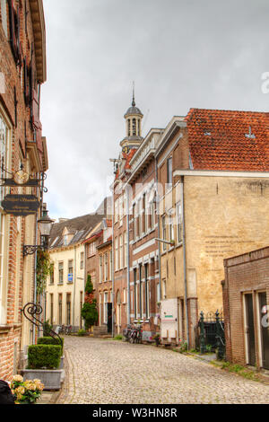 Idyllic street with historic houses and cobblestone pavement, in the background a churchtower; the charming Dutch city of Zutphen Stock Photo