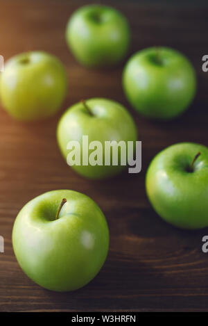 Group of green apples on brown wooden background. Stock Photo