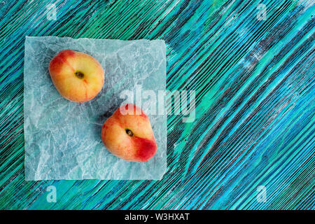 chinese flat peaches on rustic colorful background with copy space. Flat lay background. Stock Photo