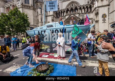 London, UK. 15th July, 2019. People bring water from across the country and pout it into a bowl. Extinction Rebellion begins another series of protests in five major cities against the criminal inaction by the government on climate and ecological collapse. The protesters brought a yacht named after Polly Higgins who fought for years for an Ecocide Law to the Royal Courts of Justice and continued her fight blocking the Strand all day with performances, discussions, speeches, music and ceremonies in front of the yacht. Credit: Peter Marshall/Alamy Live News Stock Photo