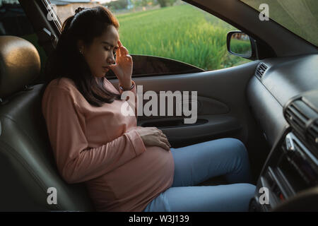 dizzy young pregnant woman on her trip in the car feeling sick Stock Photo