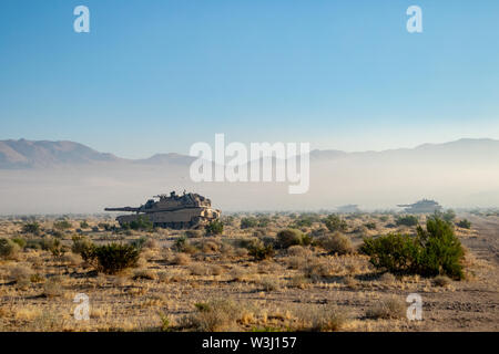 30th Armored Brigade Combat Team Abrams Main Battle Tanks get on line as they prepare to attack opposing forces in Ujen Military Training Village at the National Training Center on Ft. Irwin, CA July 14, 2019 as part of Operation Hickory Sting. The 30th ABCT is comprised of over 4,200 Soldiers that are training to deploy to Southwest Asia later this fall. Stock Photo