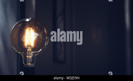 Retro light bulb on dark background with space. Lighting decor macro loft style background. Concept idea Stock Photo
