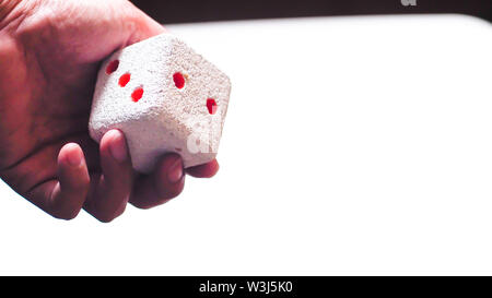 Hand & Rolling Dice. Hand rolls a dices on white isolated background. Selective focus. Dice is blur due to movement. Roll the dice concept Stock Photo