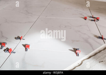 Tile leveling system with plastic clips and wedges. Stock Photo
