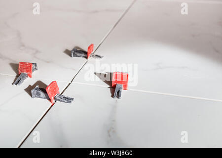 Tile leveling system with plastic clips and wedges. Stock Photo