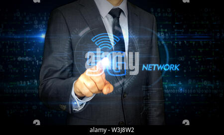 A businessman in a suit touch the screen with 5G hologram. Man using hand on virtual display interface. Wireless network, mobile communication, data t Stock Photo