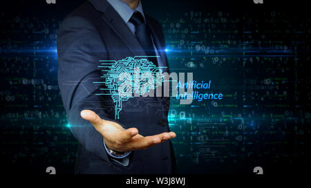 A businessman in a suit and the screen with cybernetic brain hologram. Man using hand on virtual display interface. Artificial intelligence, machine l Stock Photo
