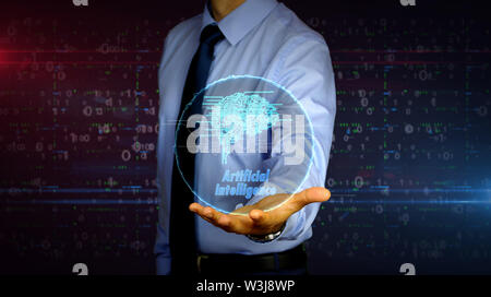 Man with dynamic cybernetic brain symbol hologram on hand. Businessman and futuristic concept of artificial intelligence, deep learning and cyber mind Stock Photo